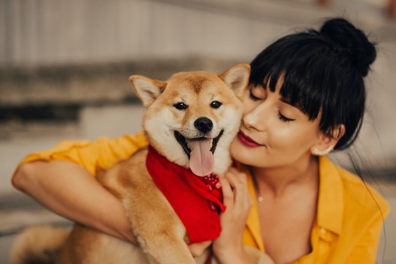 woman hugs smiling dog content with her pet savings account