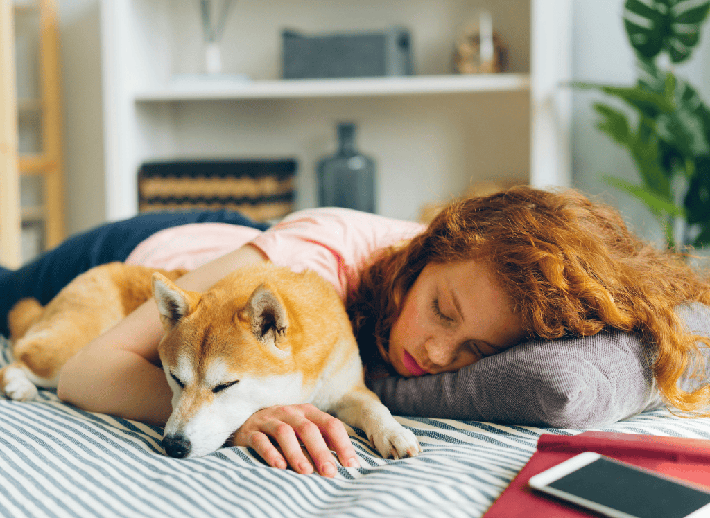 a woman sleeps with her dog