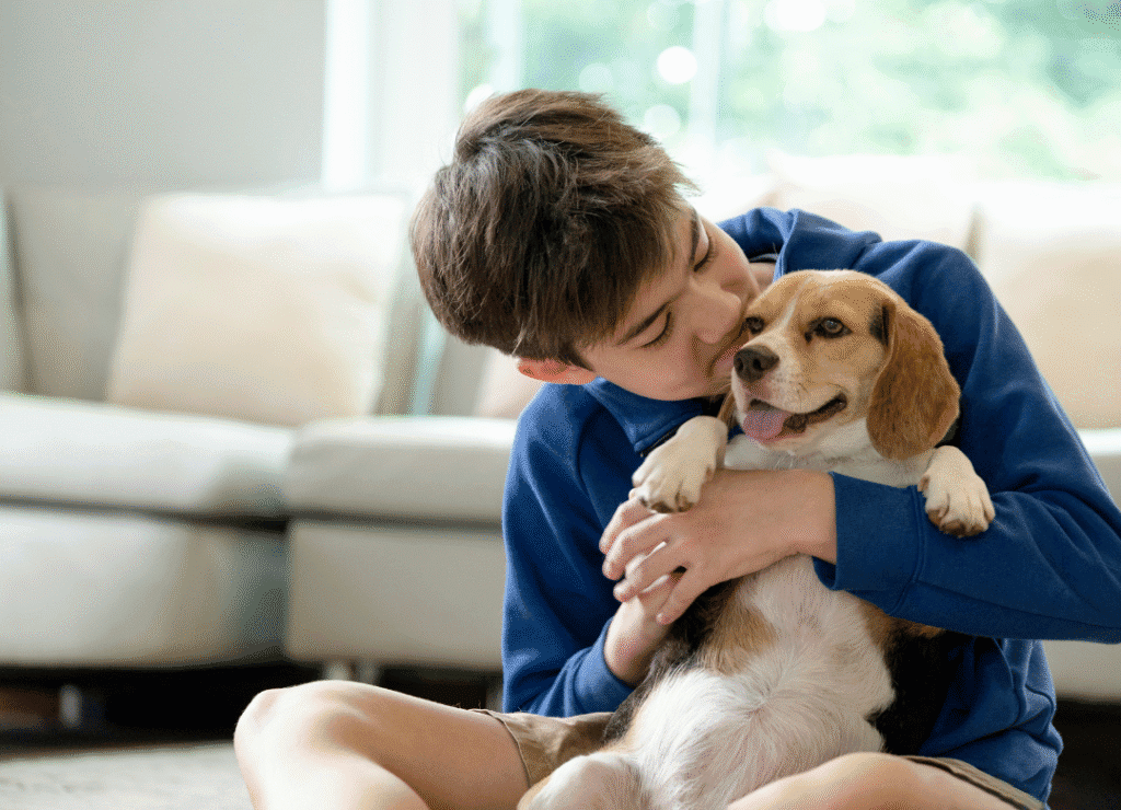 a happy little dog is hugged by his happy kid and busts the small dog myths about kids
